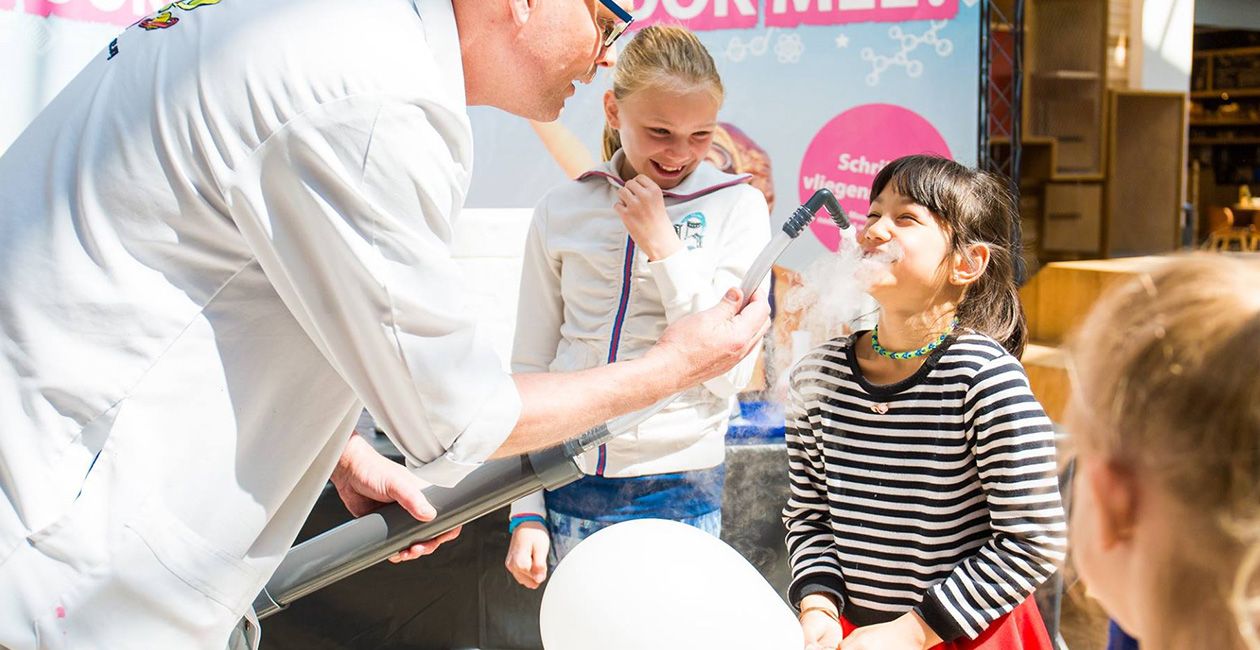 Mad scientist using a smoke machine and pouring into girls mouth